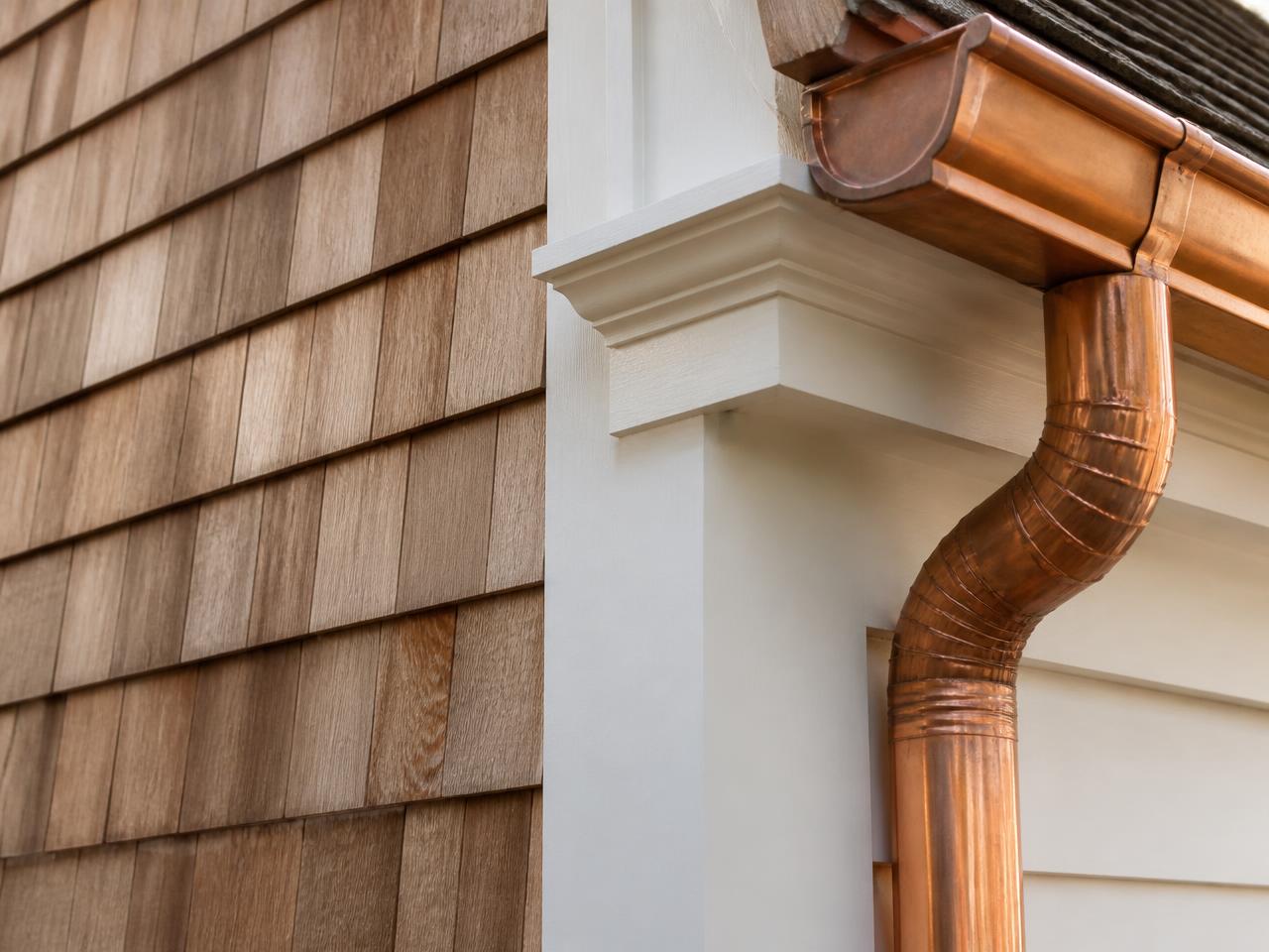 Cedar shingle siding meeting painted trim and a copper leader